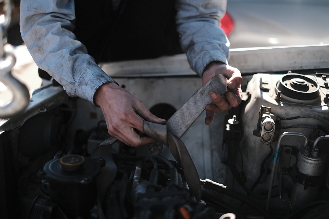 Professional mechanic working on vehicle engine bay and brake system components