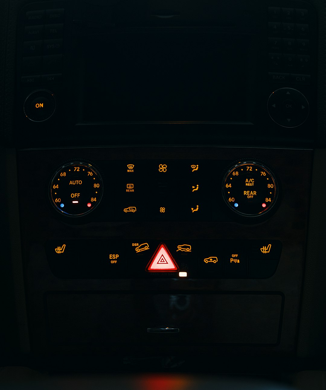 Car dashboard illuminated at night showing warning lights