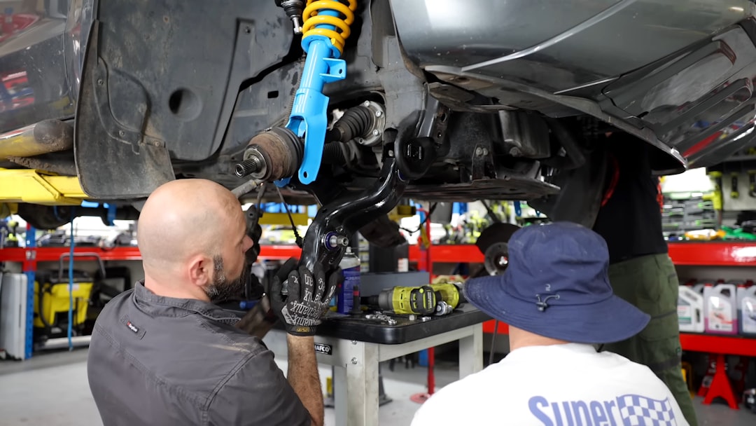 Professional transmission mechanics working in automotive repair shop